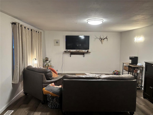 living area featuring visible vents, dark wood-type flooring, and baseboards