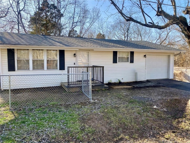 view of front of property featuring an attached garage, a shingled roof, driveway, and fence