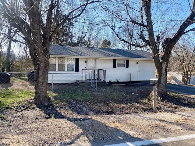 view of front of property featuring a garage, roof with shingles, driveway, and fence