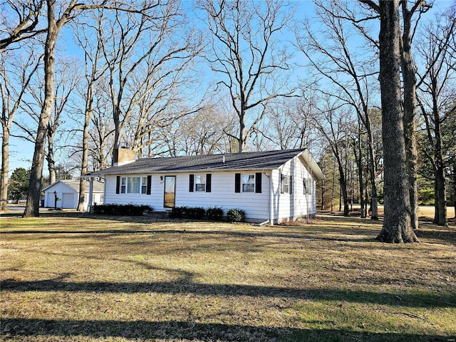 view of front of property with a front yard, an outdoor structure, and a chimney