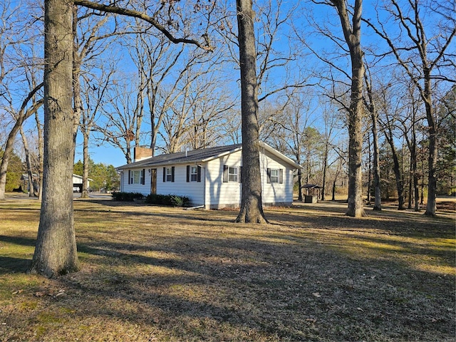 exterior space featuring a lawn and a chimney