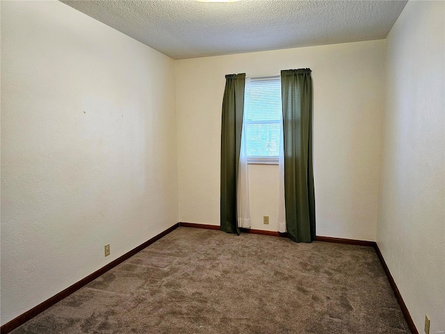 carpeted empty room with baseboards and a textured ceiling