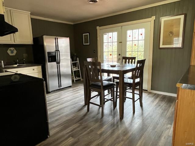 dining area featuring baseboards, ornamental molding, wood finished floors, and french doors