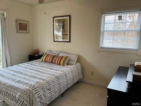 bedroom featuring ornamental molding, light carpet, ceiling fan, and baseboards