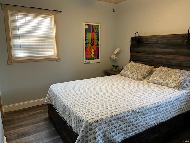 bedroom with wood finished floors and baseboards