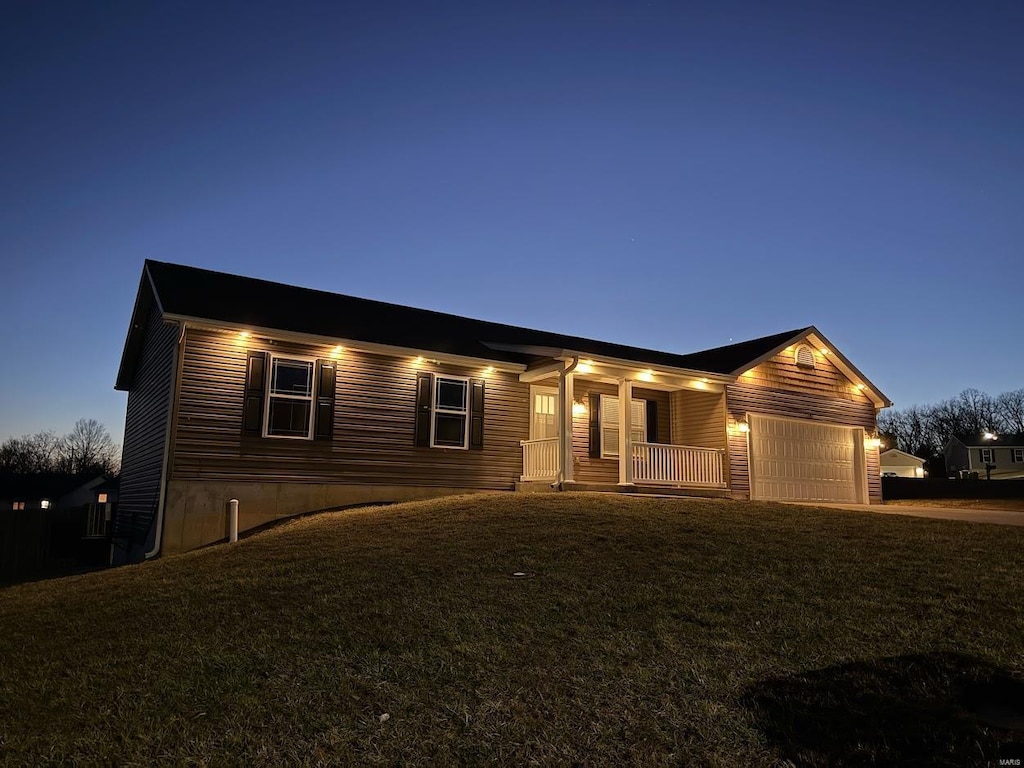 ranch-style home with a porch, a garage, driveway, and a front yard