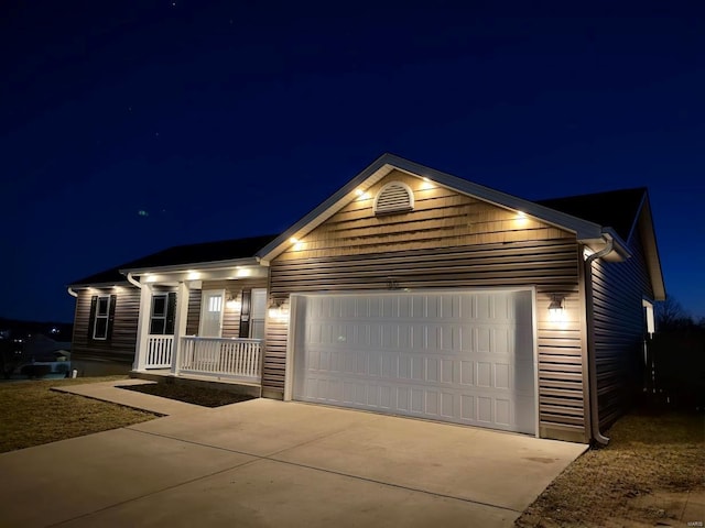 ranch-style house featuring a porch, concrete driveway, and a garage