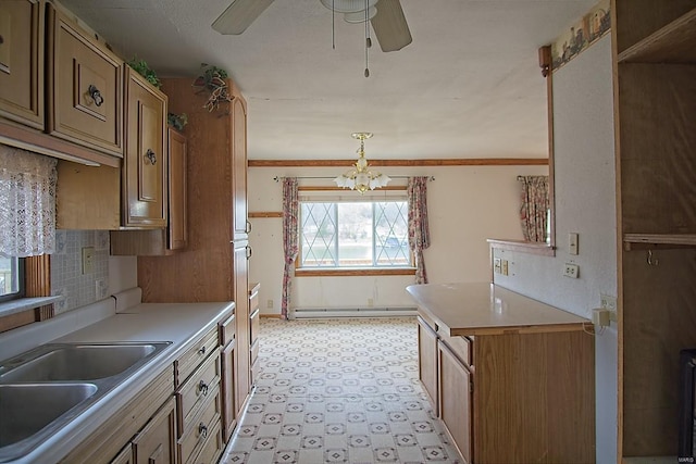 kitchen with ceiling fan with notable chandelier, a sink, a baseboard heating unit, light countertops, and light floors