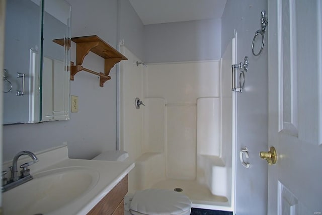 bathroom featuring toilet, vanity, and walk in shower