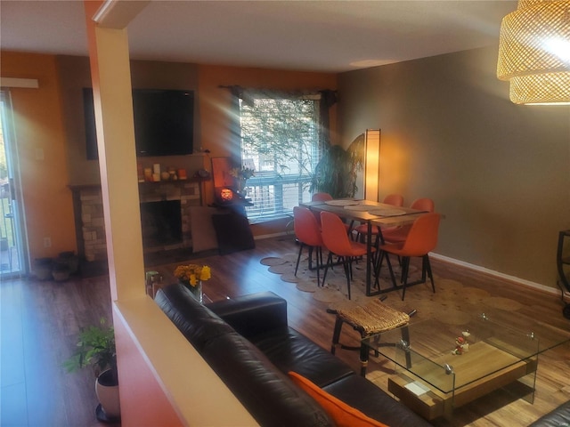 living room with a fireplace, wood finished floors, and baseboards