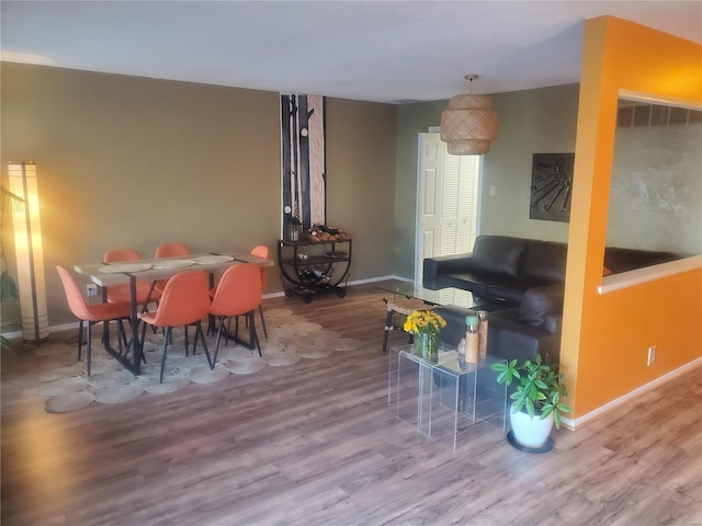 dining space with baseboards and wood finished floors