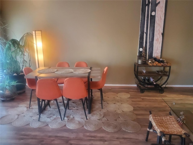 dining space featuring baseboards and wood finished floors