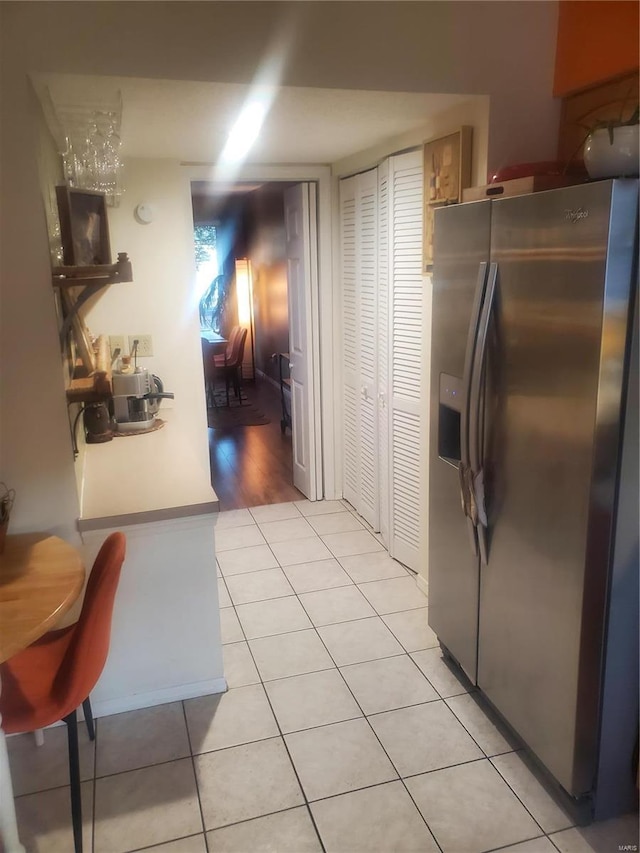 kitchen featuring light tile patterned floors and stainless steel fridge