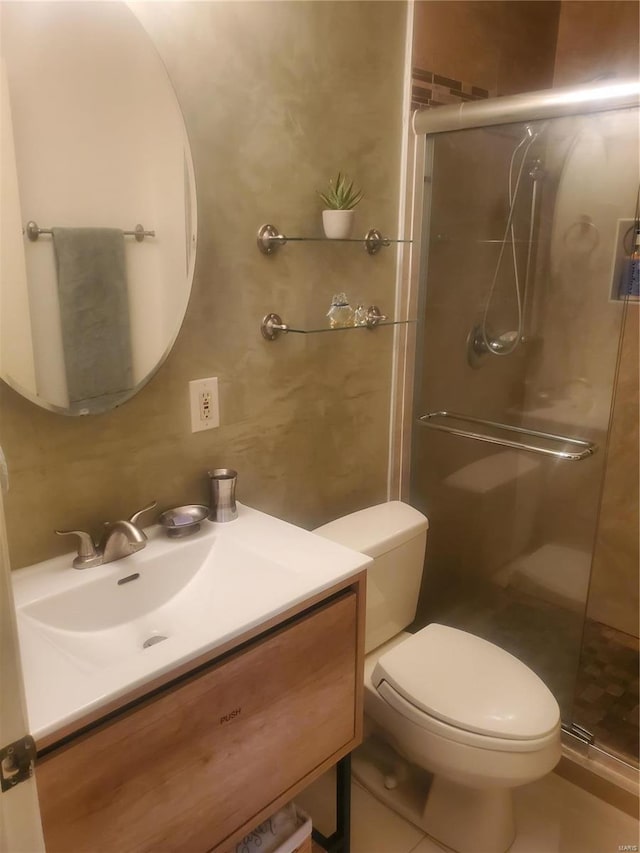 bathroom with a stall shower, vanity, and toilet