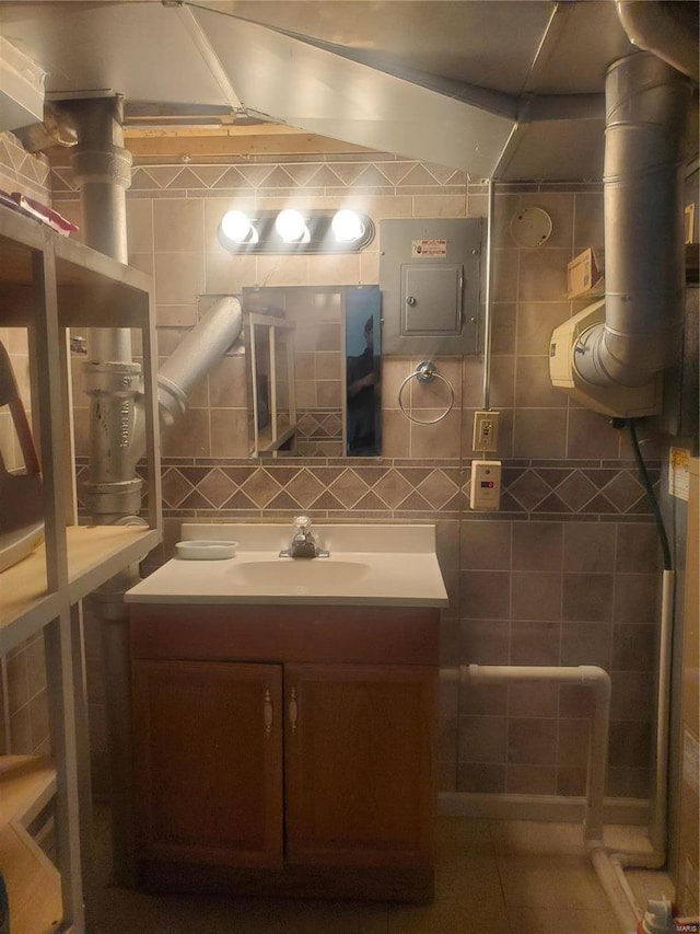 bathroom with electric panel, tile walls, backsplash, and vanity