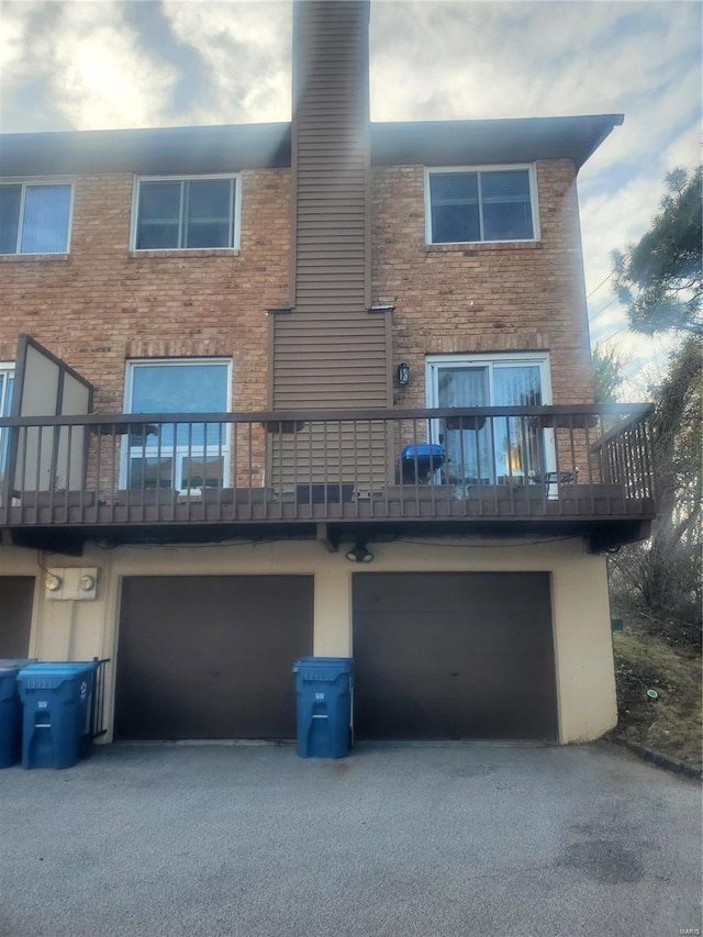 rear view of property with driveway and an attached garage