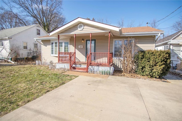 bungalow with a porch and a front lawn