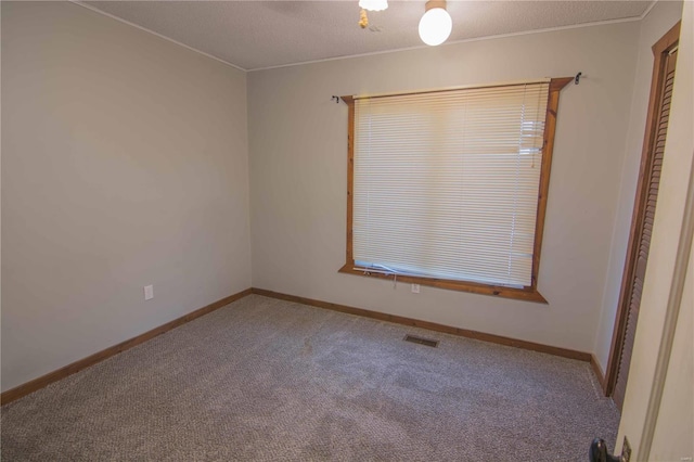 unfurnished room featuring visible vents, baseboards, and carpet flooring