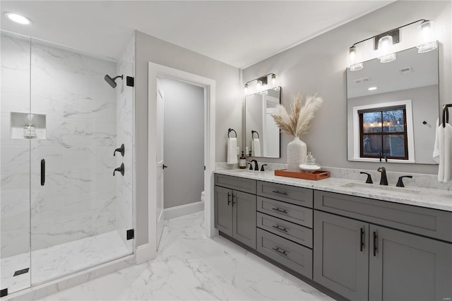 bathroom with a marble finish shower, baseboards, toilet, marble finish floor, and a sink