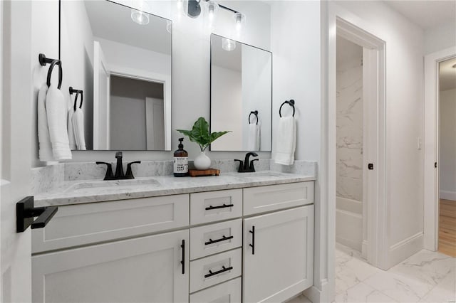 bathroom with double vanity, marble finish floor, shower / bathtub combination, and a sink