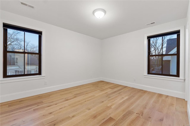 unfurnished room featuring light wood-style flooring, baseboards, and visible vents