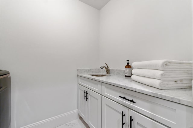 interior space featuring marble finish floor, vanity, and baseboards