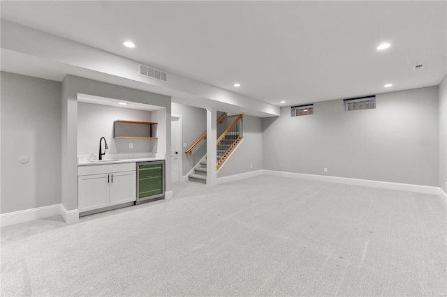 finished basement featuring visible vents, recessed lighting, a sink, wine cooler, and light carpet