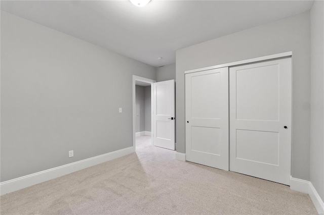 unfurnished bedroom featuring a closet, baseboards, and carpet