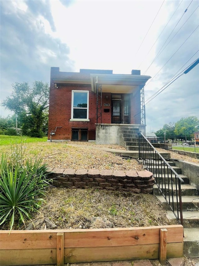 bungalow featuring covered porch and brick siding