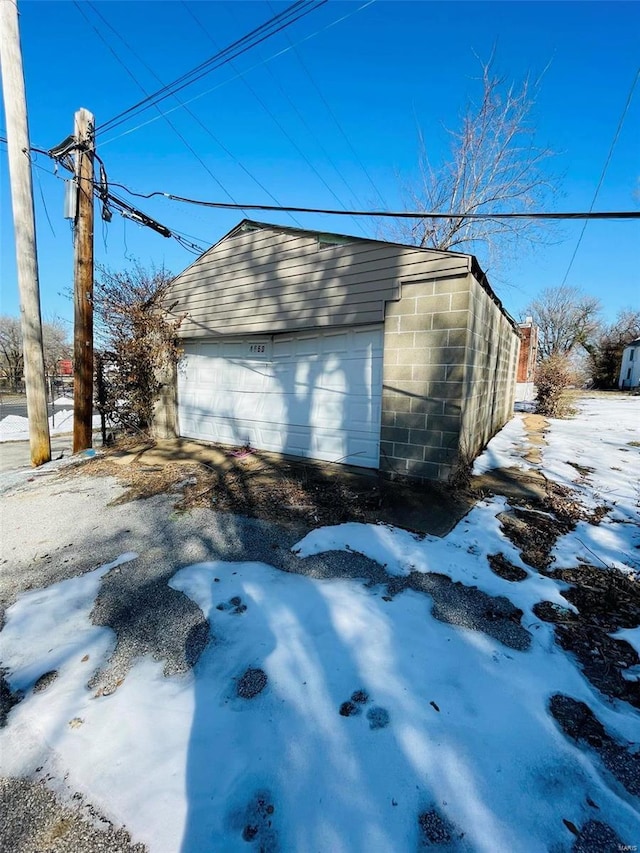 snow covered garage with a garage