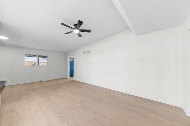 spare room featuring light wood-style flooring, a ceiling fan, visible vents, and baseboards