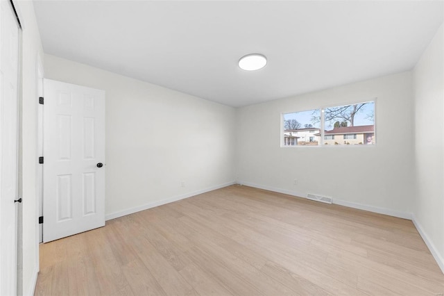 spare room with visible vents, light wood-type flooring, and baseboards