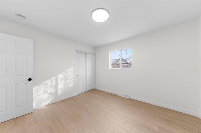 spare room with visible vents, light wood-style flooring, and baseboards