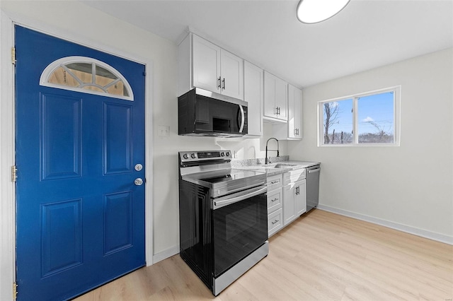 kitchen featuring white cabinetry, stainless steel appliances, and a sink