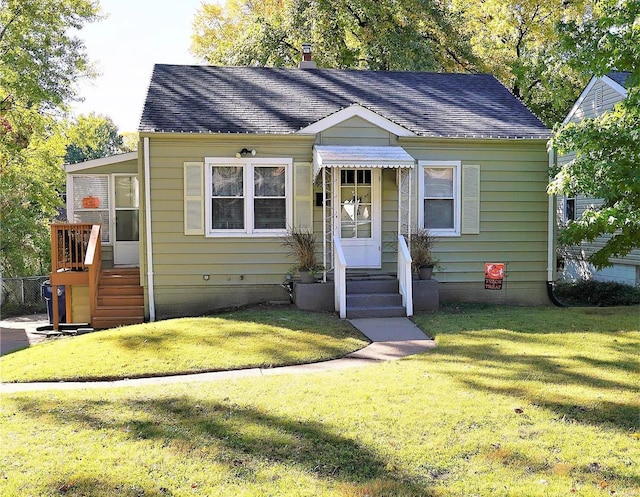 bungalow-style house featuring a front yard and a shingled roof