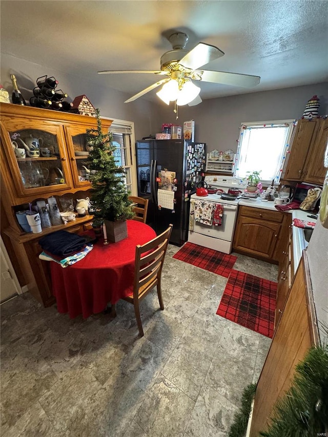 dining space featuring ceiling fan and a textured ceiling