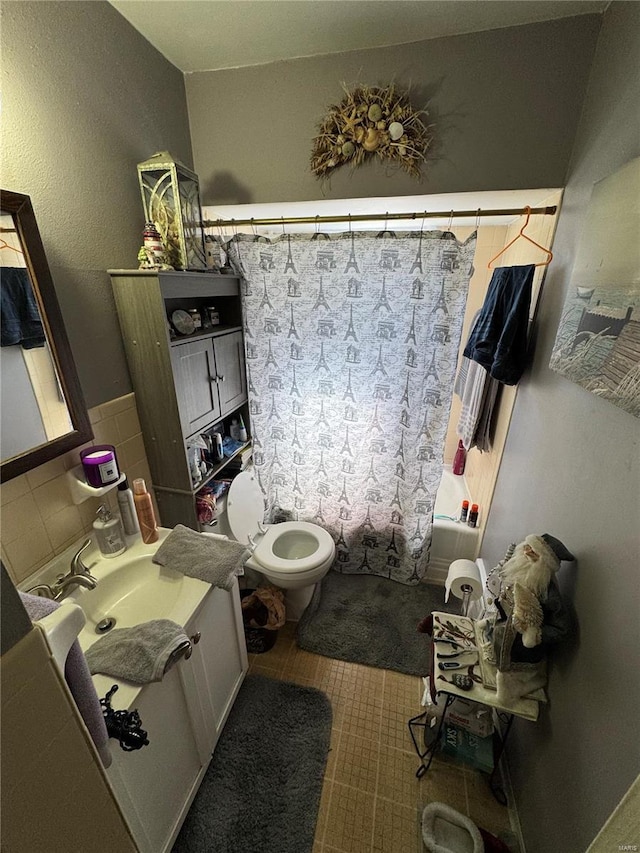 bathroom with shower / tub combo with curtain, toilet, and vanity