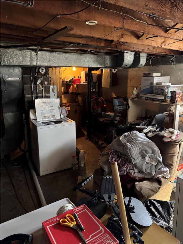 unfinished basement featuring electric panel and washer / dryer