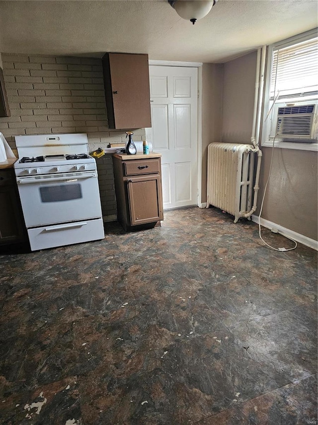 kitchen with cooling unit, white range with gas cooktop, radiator, and a textured ceiling