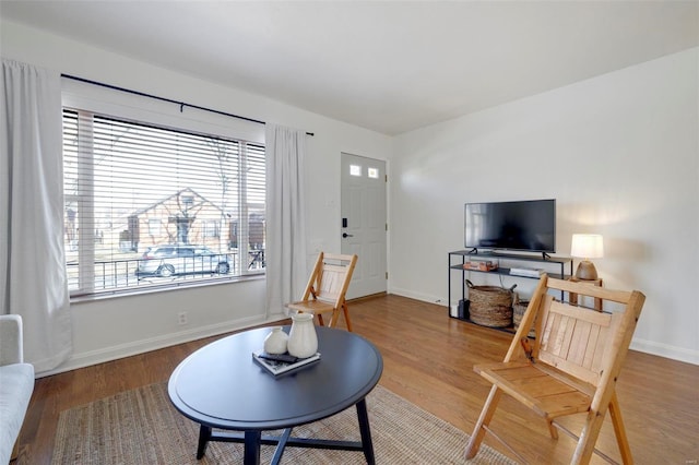 living area featuring baseboards and wood finished floors