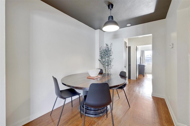 dining room with baseboards and light wood-style flooring