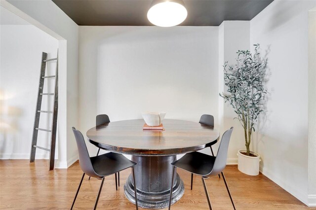 dining area featuring light wood-type flooring and baseboards