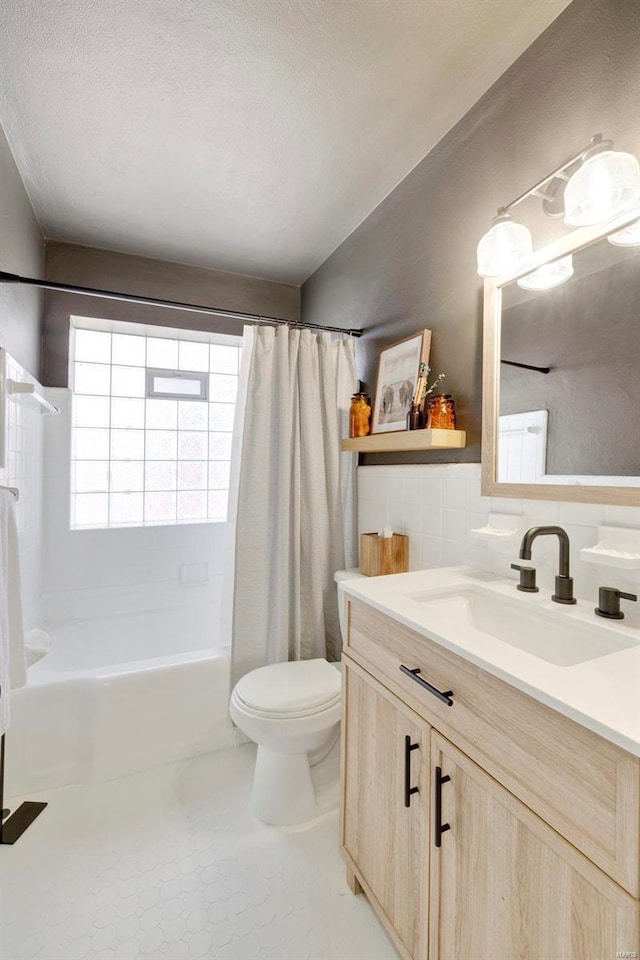 bathroom with toilet, tile walls, shower / bath combo, and a textured ceiling