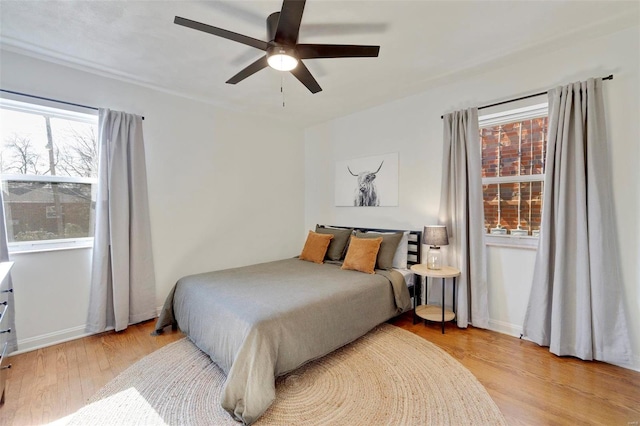 bedroom featuring baseboards, ceiling fan, and light wood finished floors