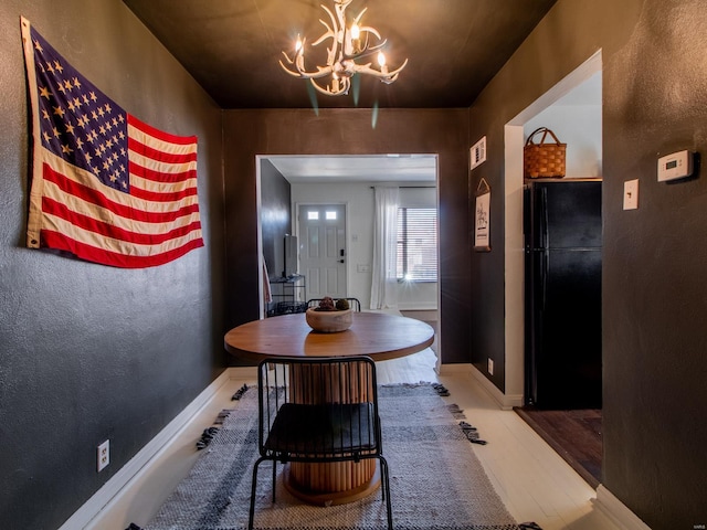 dining room featuring a notable chandelier, wood finished floors, and baseboards