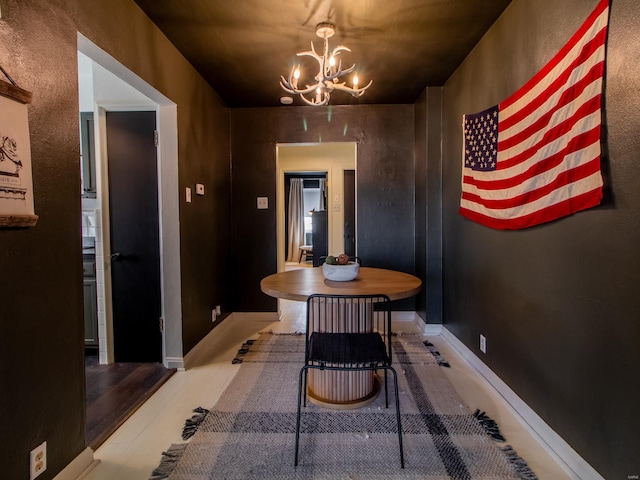 dining area with a notable chandelier, wood finished floors, and baseboards