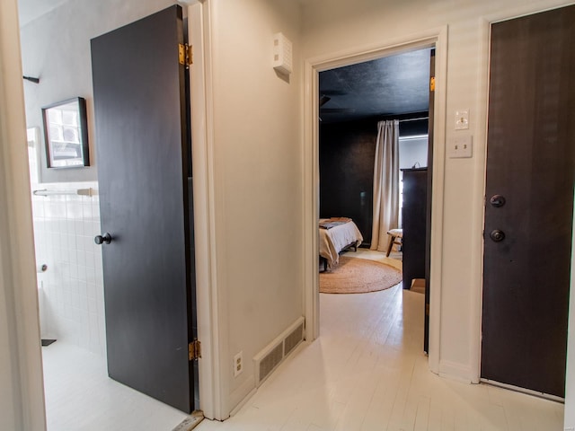 hall featuring visible vents and light wood-style flooring