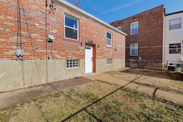 rear view of house with fence and brick siding