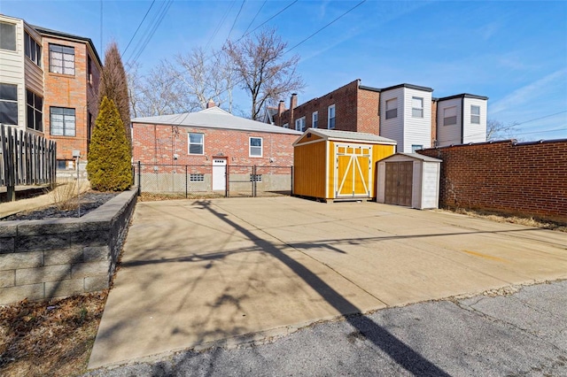 view of yard featuring a storage unit, an outdoor structure, and fence