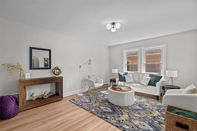 living room with visible vents, wood finished floors, and baseboards